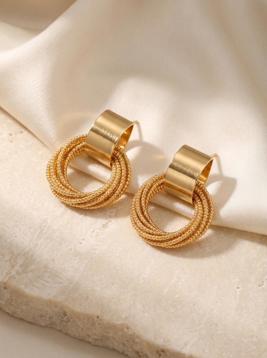 Triple Hoop Earrings in 18K gold vermeil on a cream stone block with ivory satin