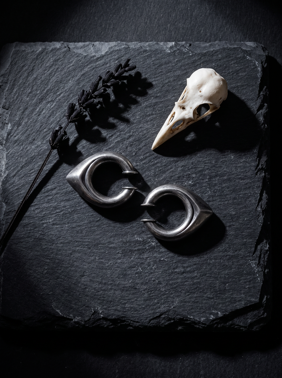 Drop Ear Cuff pair in brushed dark silver on black slate beside a bird skull and dried lavender