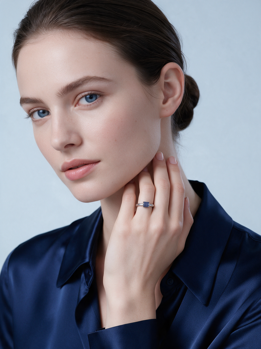 Model in a navy silk shirt wearing the Lock Ring in sterling silver with blue stones