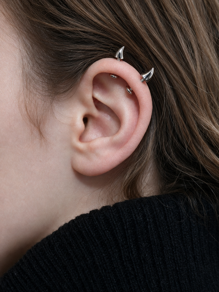 Horn Studs in oxidised silver worn high on the ear, two small curved points