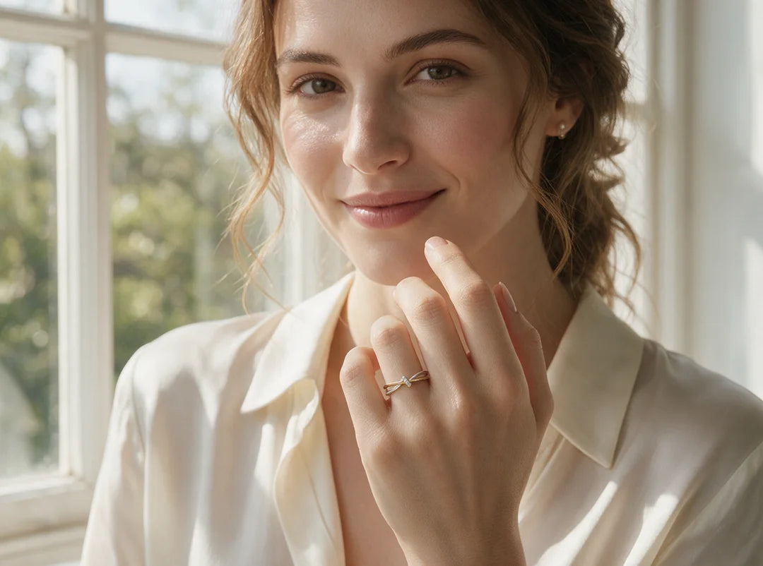 Model smiling by a sunlit window wearing the Cinch Ring in two-tone gold and silver