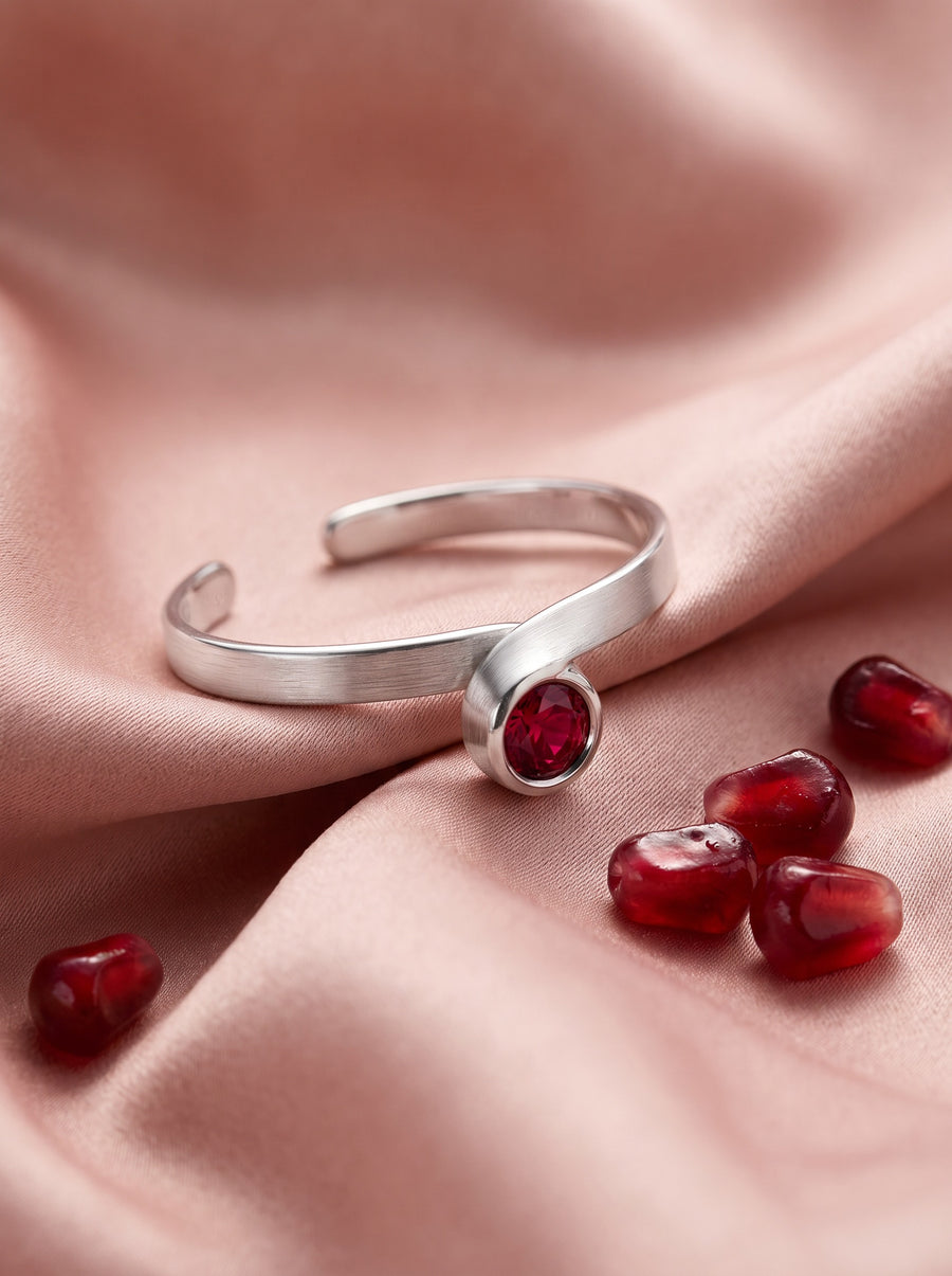 Curl Ring in Sterling Silver with a red stone on blush silk