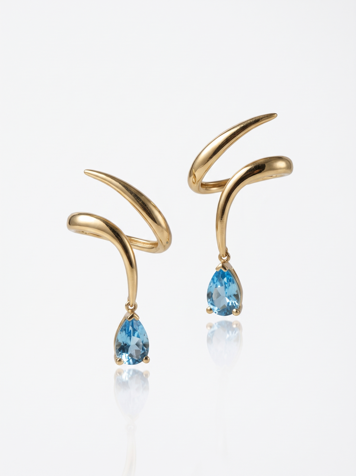 Spiral Drop Earrings in 18K gold vermeil: loose spirals ending in a light blue teardrop stone