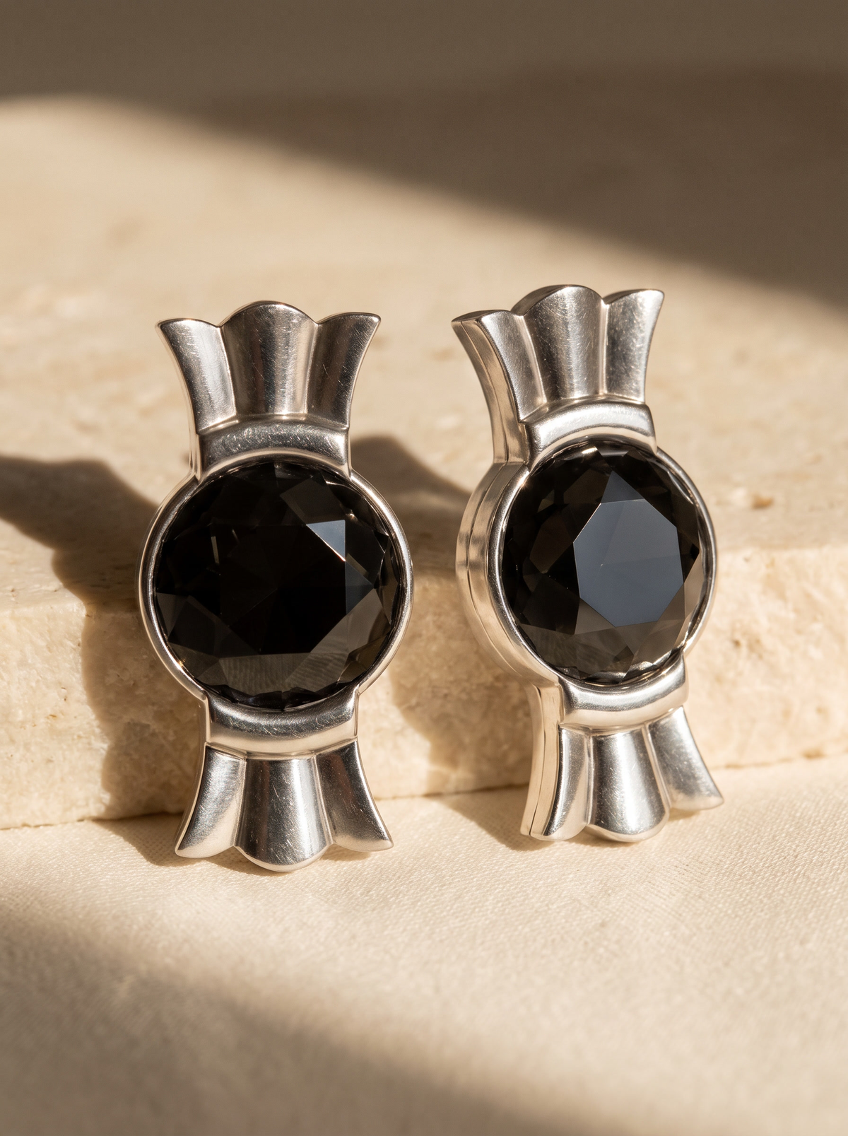 Crown Studs in sterling silver with black faceted stones on sunlit travertine