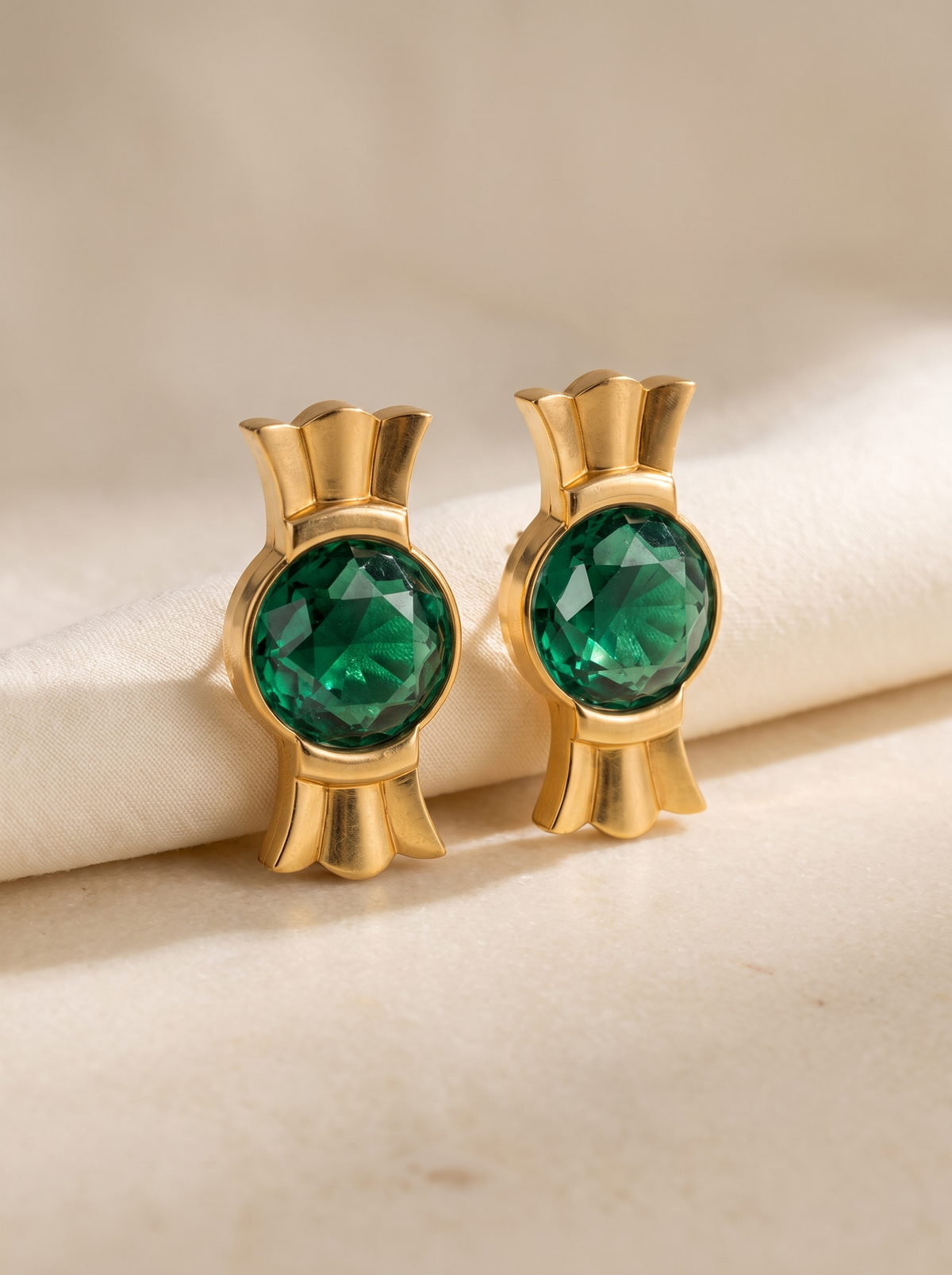 Crown Studs in 18K gold vermeil with green faceted stones on cream linen