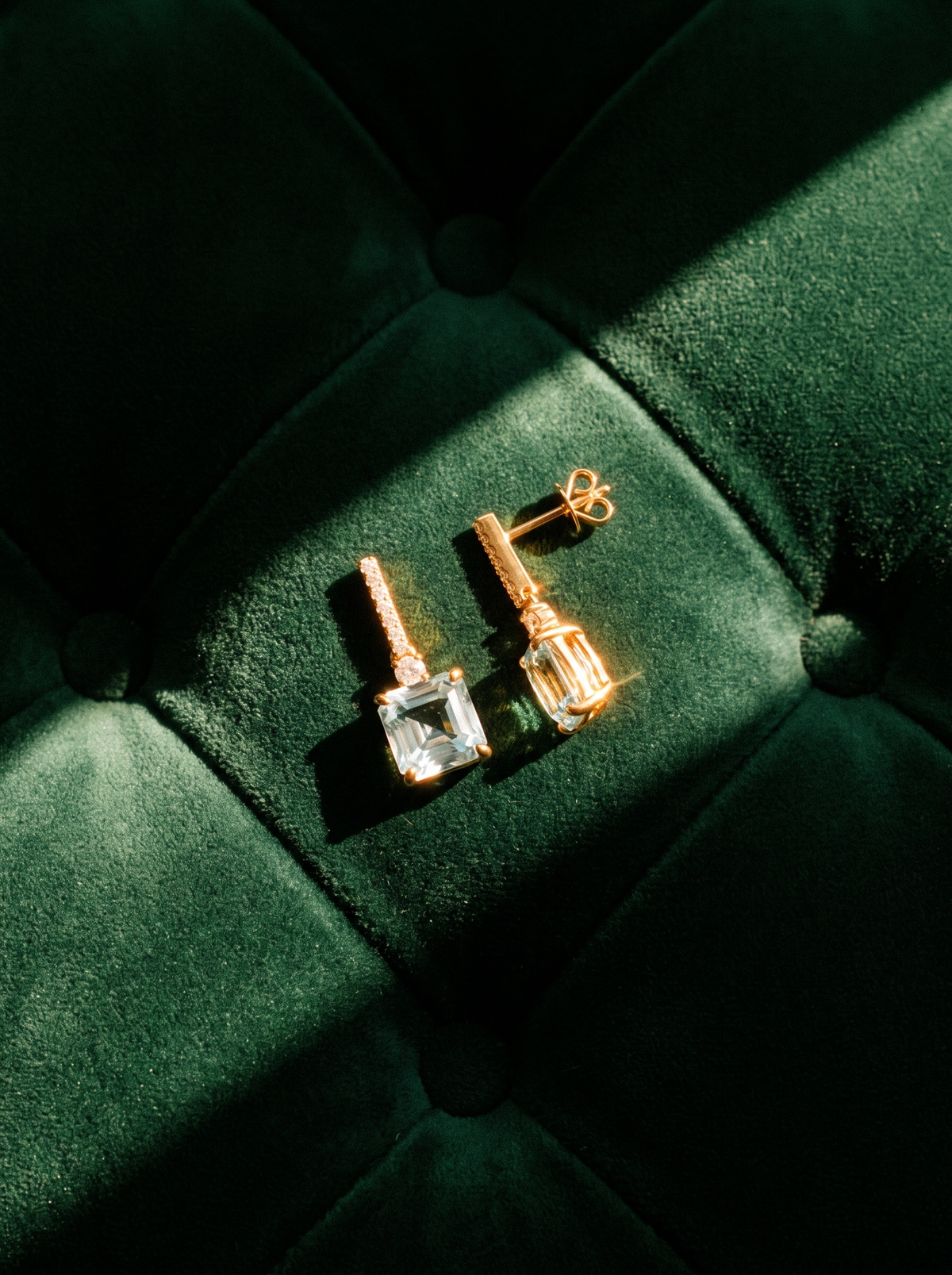 Ice Drop Earrings in 18K gold vermeil with light blue stones on green tufted velvet
