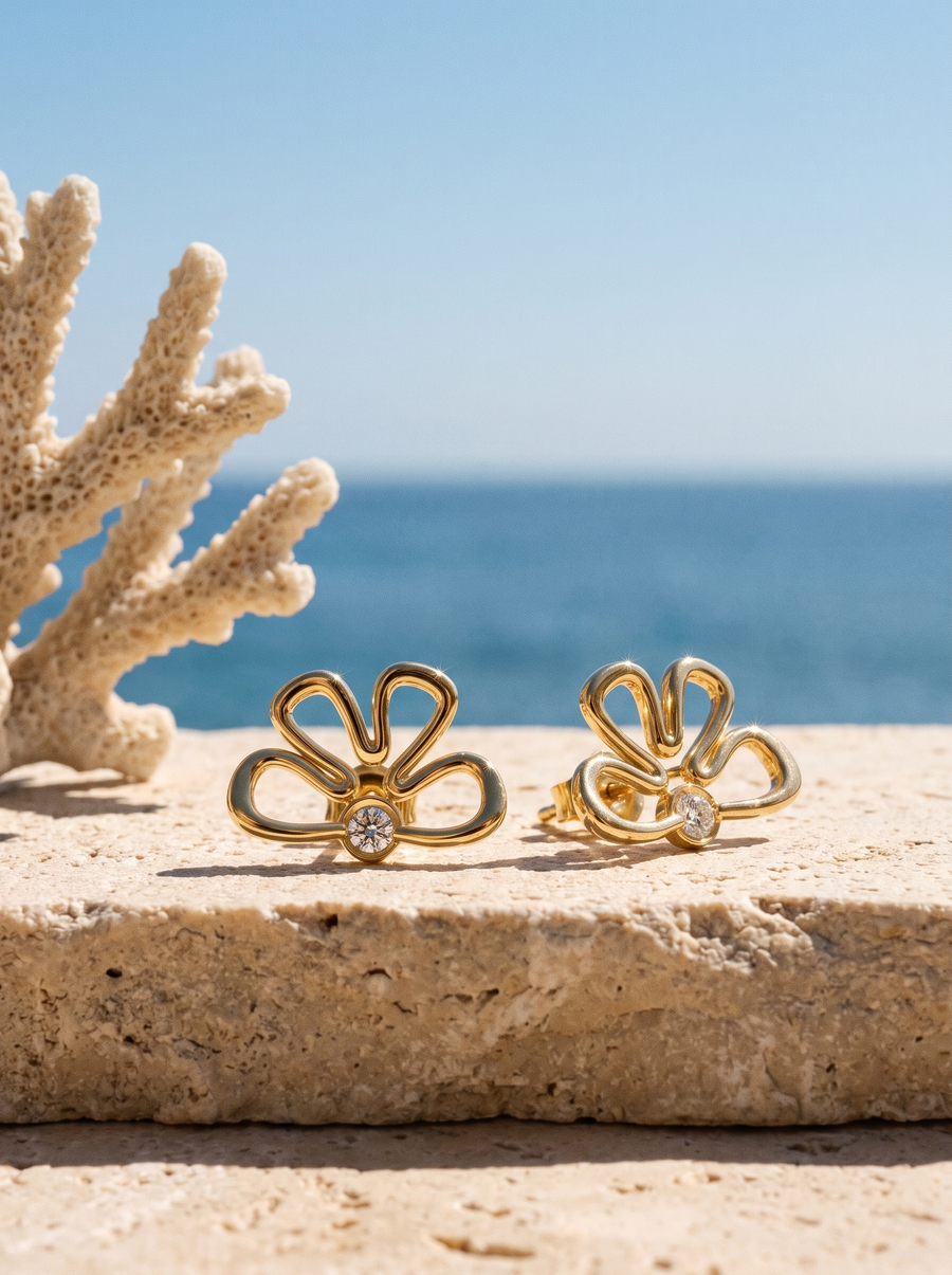 Sunflower Ear Jackets in 18K gold vermeil on a sunlit stone ledge by the sea beside white coral