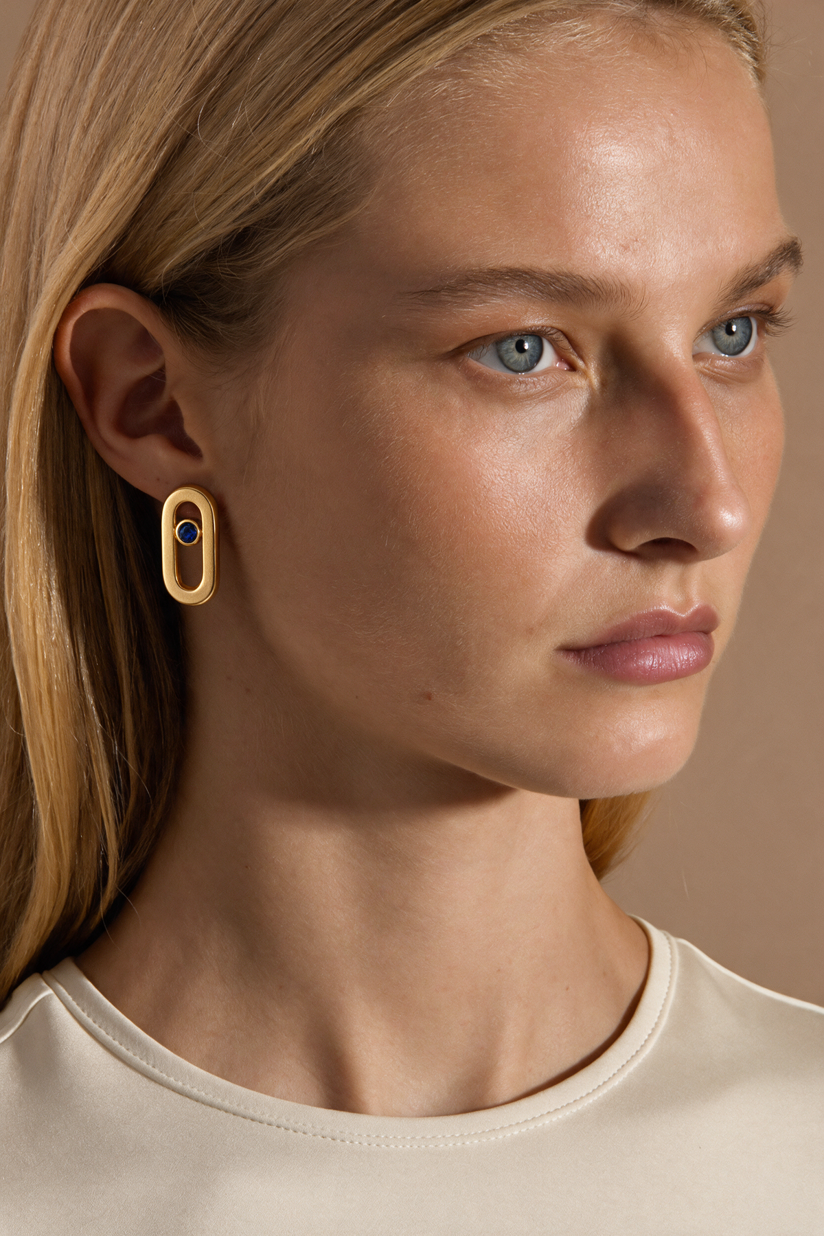 Model wearing the Bolt Studs in 18K gold vermeil with a blue stone, seen in profile