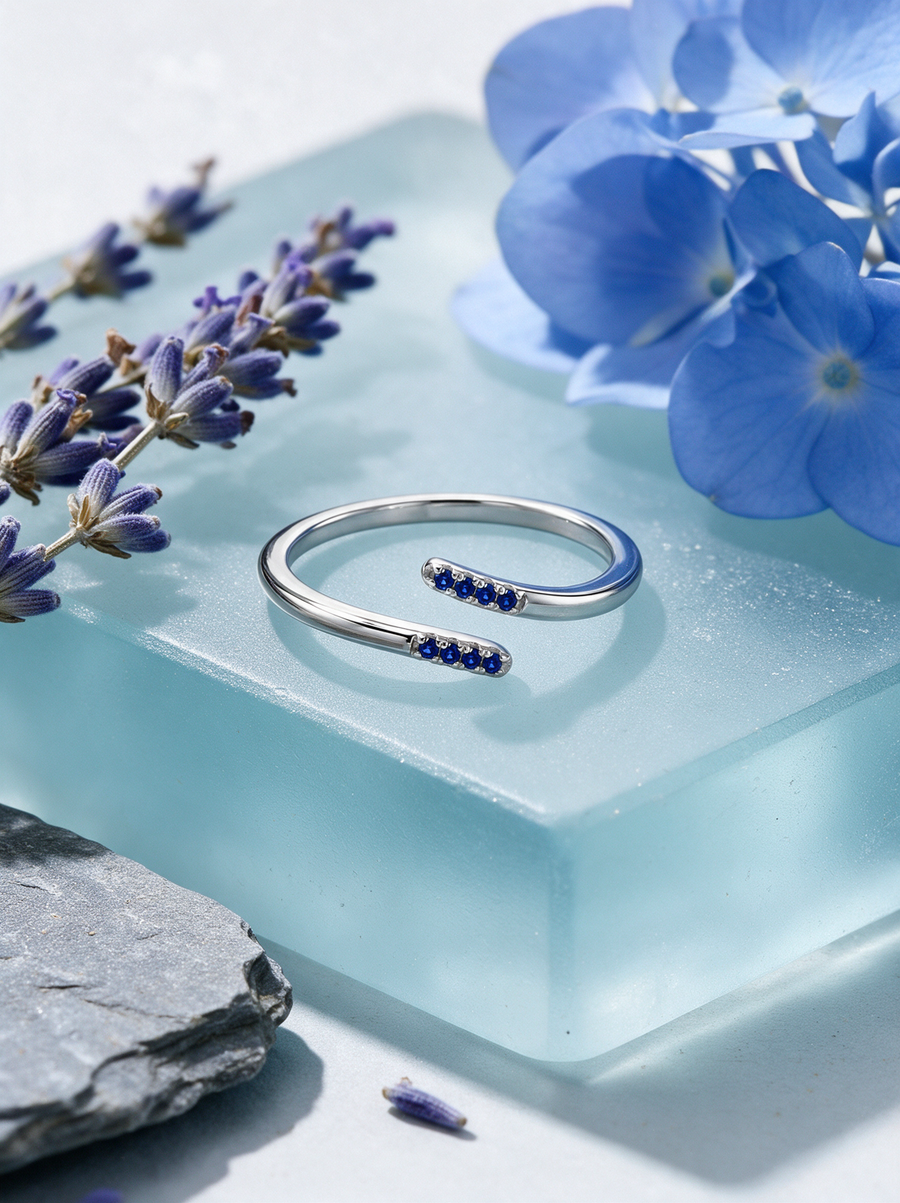 Parallel Ring in sterling silver with blue stones on a pale blue glass block with hydrangea