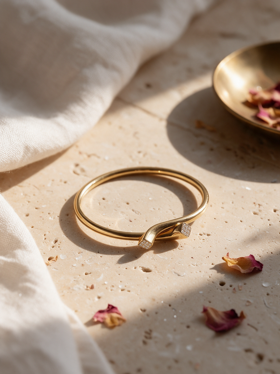 Tuck Ring in 18K gold vermeil on travertine with dried rose petals and a brass dish