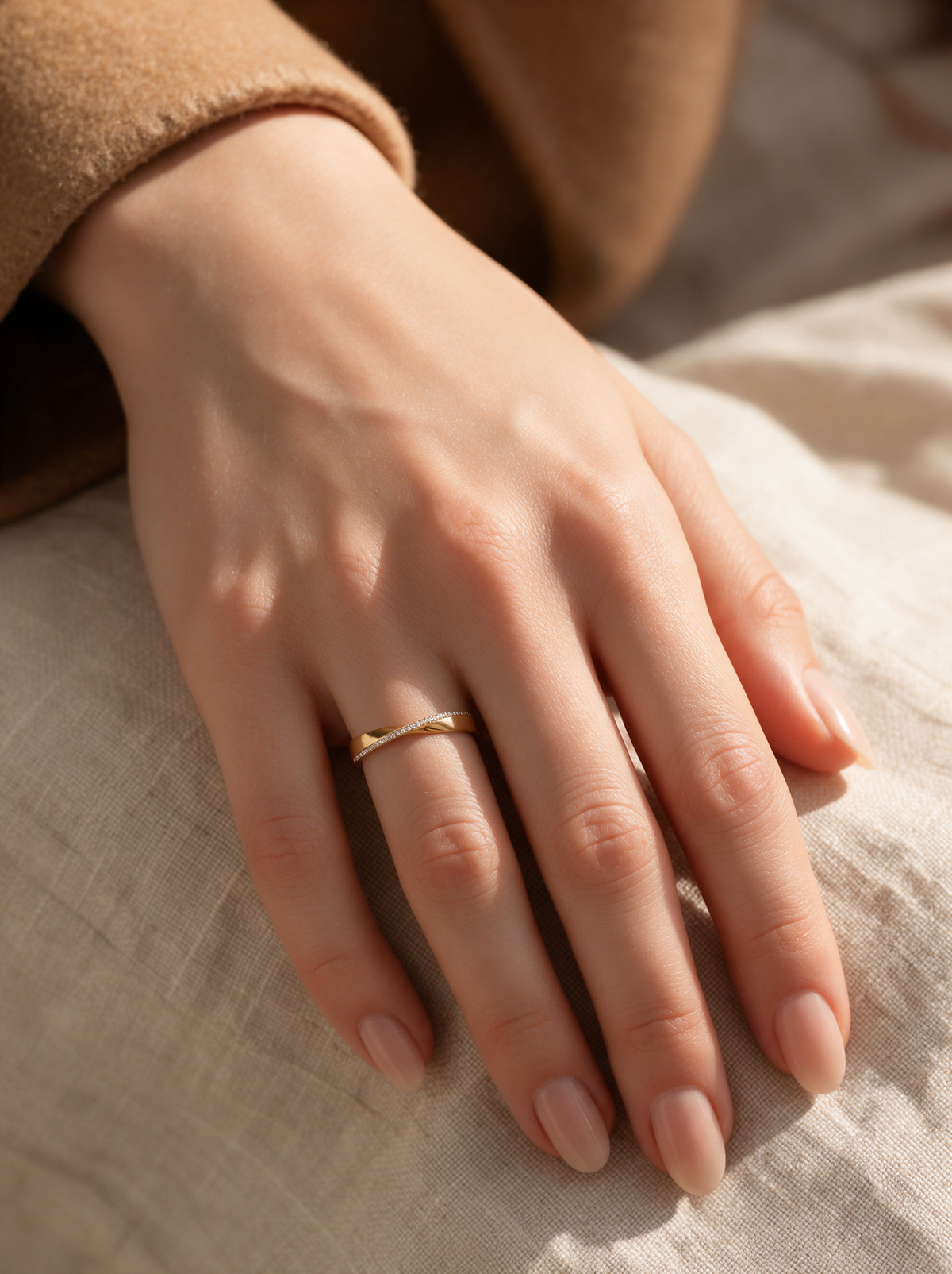 Twisted Band Ring in 18K gold vermeil on a hand resting on natural linen
