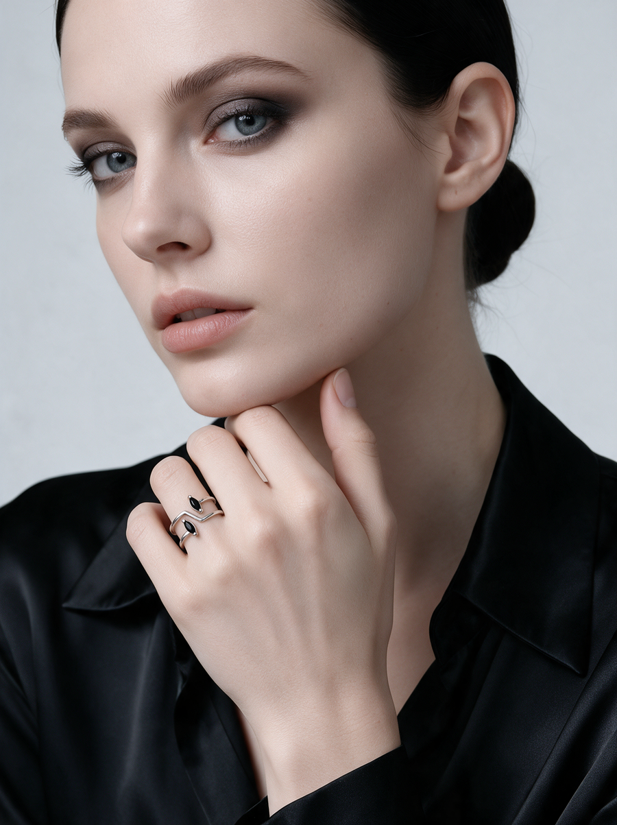 Model in black satin wearing the Switchback Ring in sterling silver with black stones