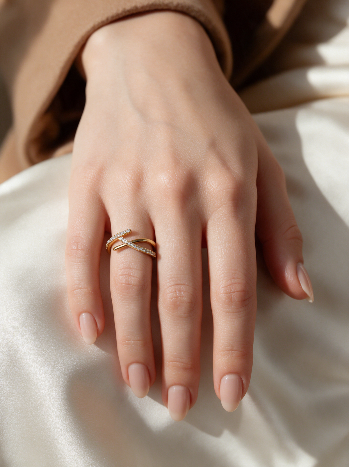 Tangent Ring in 18K gold vermeil on a hand resting on ivory satin