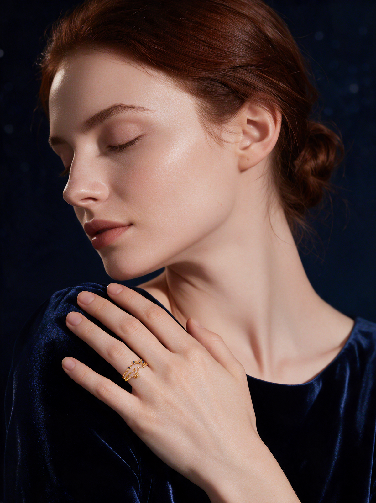 Model in navy velvet, eyes closed, wearing the Cosmic Ring in 18K gold vermeil with blue stones