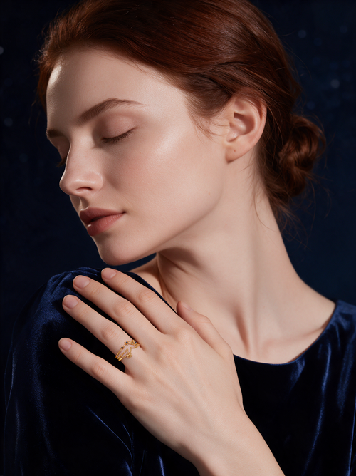 Model in navy velvet, eyes closed, wearing the Cosmic Ring in 18K gold vermeil with blue stones