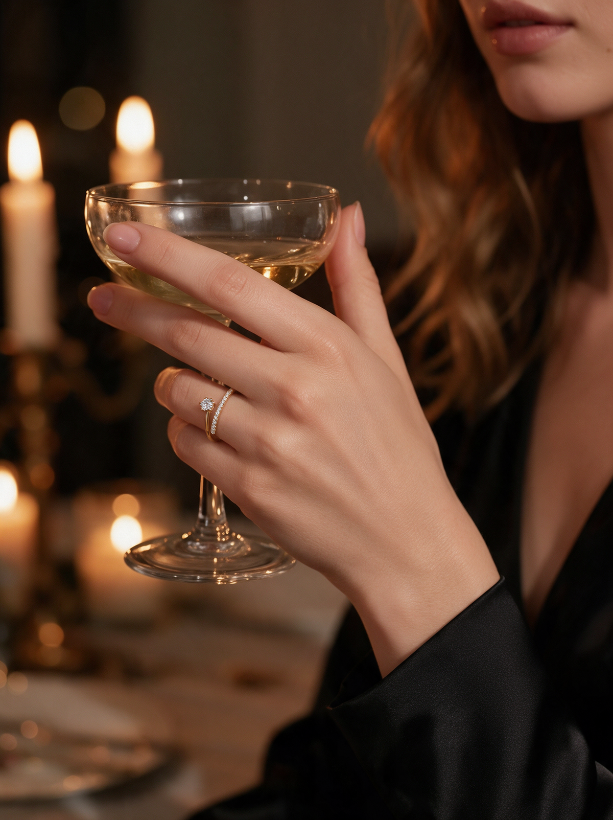 Model holding a champagne coupe by candlelight, wearing the Comet Ring in 18K gold vermeil