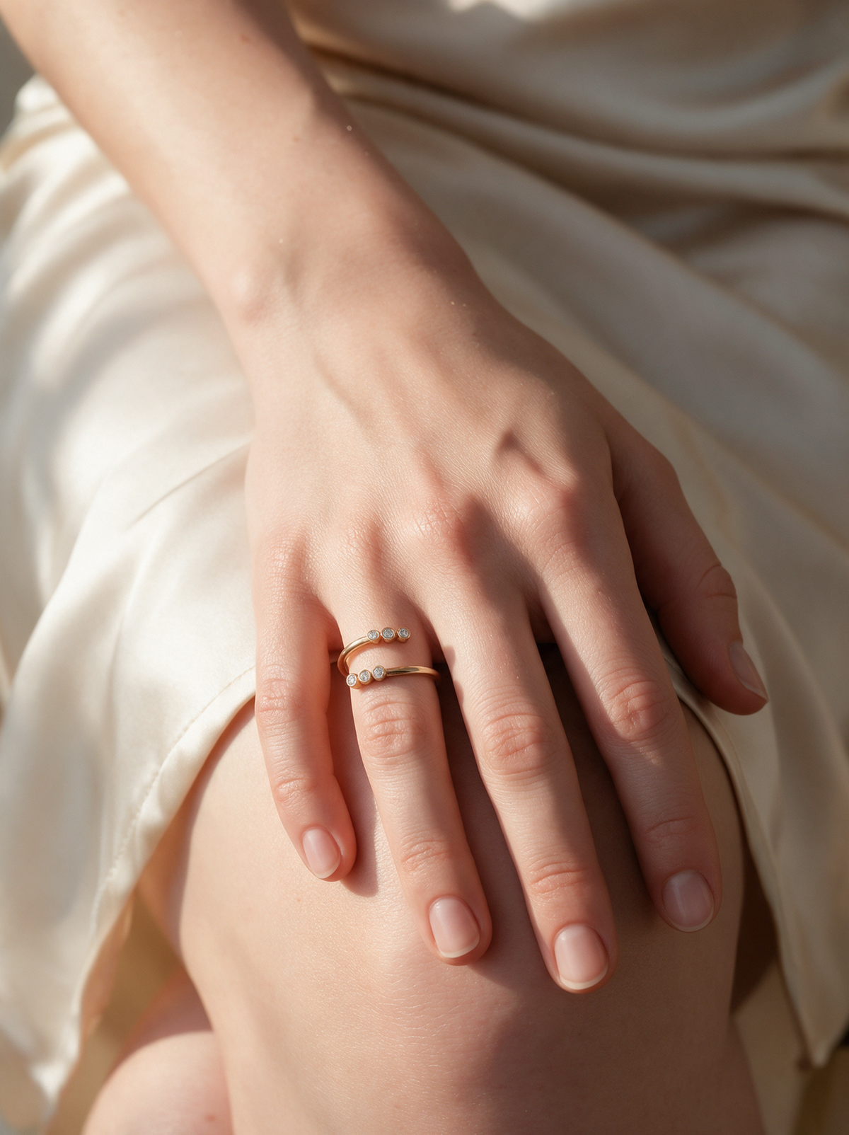 Twin Trail Ring in 18K gold vermeil with white stones on a hand resting on an ivory slip dress
