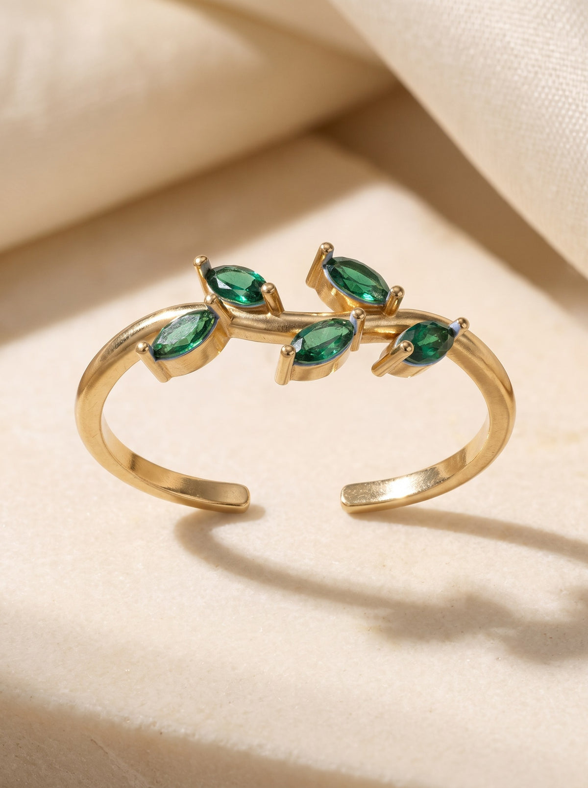 Laurel Ring in 18K gold vermeil: an open band with five green marquise stones set like leaves on a vine